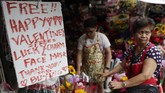 Wabah virus corona membuat penjual bunga di Filipina memiliki cara unik untuk menarik pembeli. 'Bunga keberuntungan' dan masker menjadi trik promosi perayaan Hari Valentine di Manila. (AP Photo/Aaron Favila)