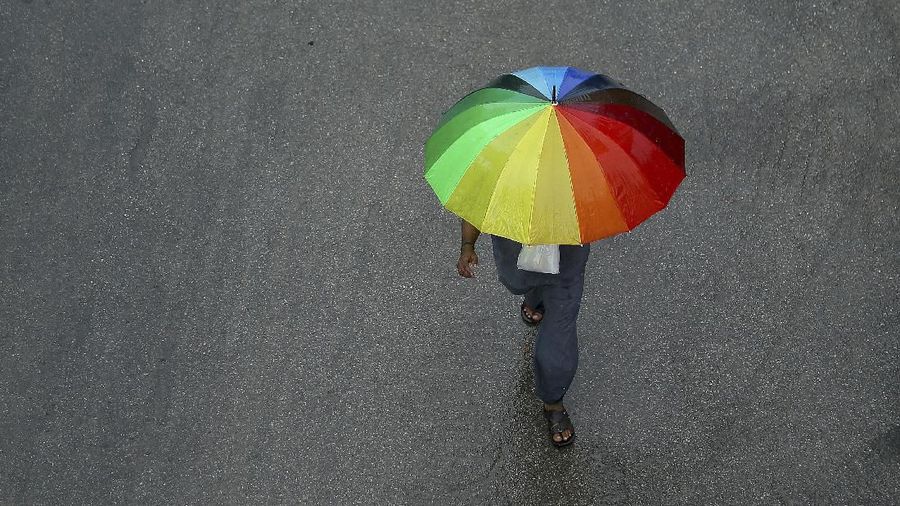 An Indian man walks with an umbrella during a rain in Hyderabad, India, Thursday, Aug. 1, 2019. India receives its monsoon rains from June to September. (AP Photo/Mahesh Kumar A.)