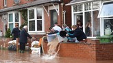 Dua sungai di selatan Wales meluap pada Minggu pekan lalu membuat kawasan pemukiman di sekitarnya terendam. (Photo by Oli SCARFF / AFP)