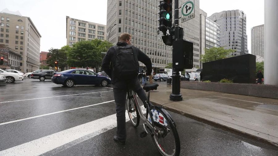 A biker waits at a traffic light in Montreal, Canada, Thursday, June 6, 2013. (AP Photo/Luca Bruno)