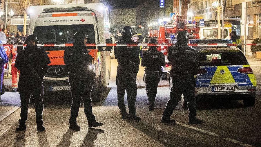 Police stand guard near the scene of a shooting in central Hanau, Germany Thursday, Feb. 20, 2020. German police say several people were shot to death in the city of Hanau on Wednesday evening. (AP Photo/Michael Probst)