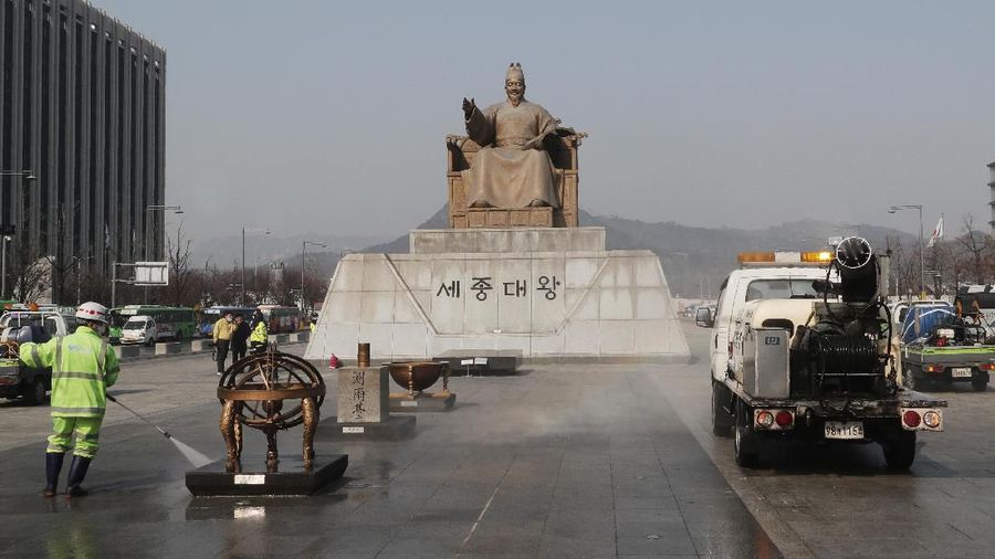 A worker and vehicle spray disinfectant and water as a precaution against the new coronavirus in front of the statue of King Sejong in the Joseon Dynasty, at the Gwanghwamun Plaza in Seoul, Thursday, Feb. 20. The mayor of the South Korean city of Daegu urged its 2.5 million people on Thursday to refrain from going outside as cases of the new virus spike. (AP Photo/Ahn Young-joon)