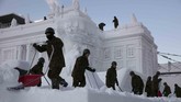 Anggota Angkatan Bersenjata membersihkan tumpukan salju pada patung Istana Polandia yang dibangun di Festival Salju Sappporo di Jepang. (AP Photo/Jae C. Hong)