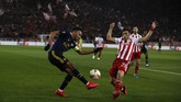Kapten Arsenal, Pierre-Emerick Aubameyang, coba melepaskan umpan meski dikawal ketat pemain Olympiakos, Kostas Tsimikas, pada leg pertama babak 32 besar Liga Europa di Stadion Georgios Karaiskakis. (AP Photo/Thanassis Stavrakis)