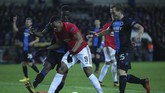 Penyerang Manchester United, Anthony Martial, dikepung dua pemain Club Brugge, Odilon Kossounou (kiri) dan Ruud Vormer pada laga leg pertama 32 besar Liga Europa. (AP Photo/Francisco Seco)