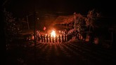Perempuan-perempuan suku Naga di Satpalaw Shaung, kota Sagaing, Myanmar, mengelilingi api unggun dalam suatu ritual pemberkatan hasil panen. (Photo by Ye Aung THU / AFP)