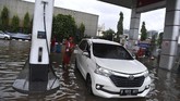 Karyawan melayani pengisian bahan bakar minyak (BBM) saat banjir menggenangi SPBU Pertamina di Jalan Danau Sunter Selatan, Sunter Jaya, Jakarta Utara, Minggu (23/2/2020). (ANTARA FOTO/Sigid Kurniawan)