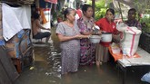 Warga membagikan beras saat banjir merendam di Jalan Anyer, Menteng, Jakarta, Minggu (23/2/2020). (ANTARA FOTO/M Risyal Hidayat)