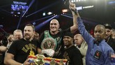 Tyson Fury merayakan gelar kelas berat WBC usai mengalahkan Deontay Wilder. Tyson Fury menjadi petarung pertama yang pernah merasakan seluruh gelar juara dunia badan dunia. (AP Photo/Isaac Brekken)