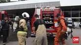 Petugas pemadam kebakaran melepaskan pakaian khusus yang ia kenakan setelah memastikan asap di Gedung Nusantara III bukan berasal dari sumber api. (CNN Indonesia/Safir Makki)