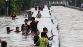 Anak-anak bermain air saat banjir yang menggenangi Perumahan Pondok Maharta, Pondok Kacang, Tangerang Selatan, Banten, Selasa (25/2/2020). ANTARA FOTO/Rivan Awal Lingga