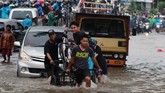 Pengendara menggunakan jasa ojek gerobak untuk menghindar banjir yang merendam Jalan Raden Patah, Ciledug, Tangerang, Banten, Selasa (25/2/2020). ANTARA FOTO/Muhammad Iqbal