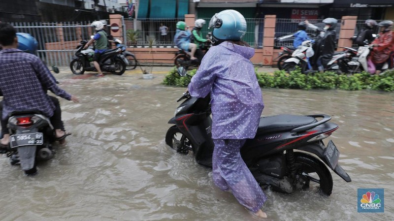 Terlihat puluhan motor terpaksa melawati jalur pejalan kaki untuk menghindari banjir.