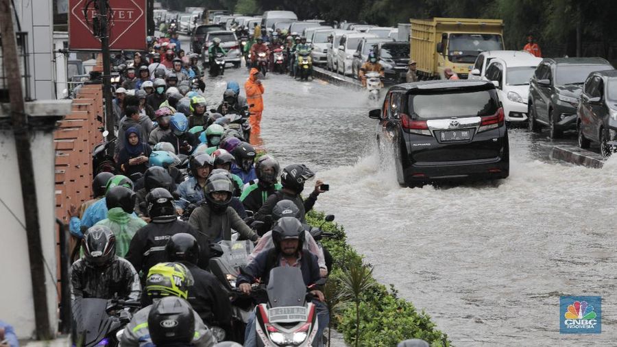 Terlihat puluhan motor terpaksa melawati jalur pejalan kaki untuk menghindari banjir.