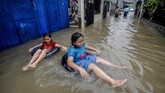 Dua orang anak bermain air saat banjir di kawasan Cilangkap, Jakarta Timur, Selasa (25/2/2020). Banjir kerap dimanfaatkan oleh anak-anak untuk berenang meski air keruh. ANTARA FOTO/Yulius Satria Wijaya/foc.