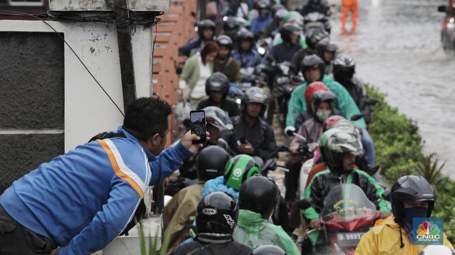Terlihat puluhan motor terpaksa melawati jalur pejalan kaki untuk menghindari banjir.