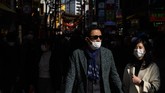 Para pejalan kaki di wilayah Pecinan di Yokohama, Jepang, berjalan-jalan menggunakan masker. (Photo by Philip FONG / AFP)