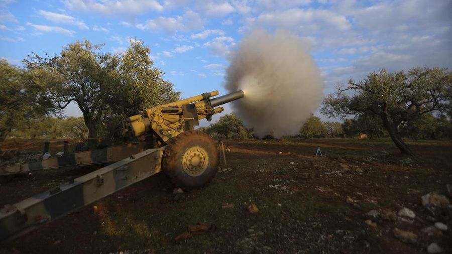 Turkish backed Syrian fighters fire a howitzer near the village of Neirab, in Idlib province, Syria, Monday, Feb. 24, 2020. (AP Photo/Ghaith Alsayed)