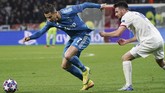 Pemain sayap Lyon, Leo Dubois, berupaya menahan laju Ronaldo dengan menarik jersey sang pemain gaek. (AP Photo/Laurent Cipriani)