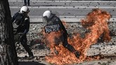 Penduduk setempat berencana tetap akan menggelar aksi demo jika pemerintah tetap melanjutkan rencana membangun kamp pengungsi. (Photo by ARIS MESSINIS / AFP)