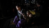 Ku Myo (35), perempuan anggota Suku Naga, dengan badan penuh tato sedang menggendong anaknya. (Ye Aung THU / AFP)