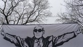 Seorang pendukung membentangkan bendera saat Roger Stone, mantan penasihat Presiden Amerika Serikat Donald Trump, tiba di pengadilan di Washington, DC. (Alex Edelman / AFP)