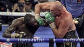 Tyson Fury mendaratkan pukulan telak ke wajah Deontay Wilder. Fury menang TKO di ronde ketujuh setelah sudut ring Wilder melempar handuk. (Photo by John Gurzinski / AFP)