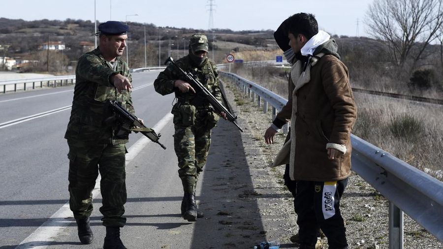 Para migran berkumpul di sebuah ladang dekat Edirne, di perbatasan Turki-Yunani. (AP/Giannis Papanikos)