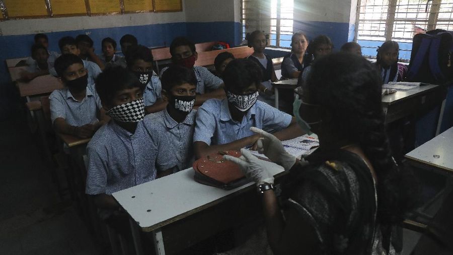Virus corona membuat warga dunia gunakan masker untuk cegah penyebaran COVID-19. Siswa di India pun tak ketinggalan pakai masker buatan sendiri saat bersekolah