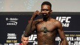 Israel Adesanya mencium cerutu Kuba saat menjalani sesi timbang badan jelang duel UFC 248, Sabtu (7/3) malam waktu setempat. (Steve Marcus/Las Vegas Sun via AP)