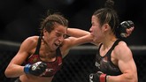 Zhang Weili yang unggul endurance atas Joanna Jedrzejczyk mulai membalas usai ronde kedua. Duel sengit pun terjadi. (Harry How/Getty Images/AFP)