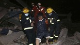 Tim penyelamat membantu pria keluar dari reruntuhan hotel di Quanzhou, China. Hotel yang digunakan sebagai tempat karantina virus corona tersebut ambruk Sabtu (7/3). (Chinatopix via AP).
