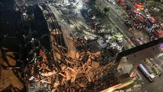  Tim penyelamat  mencari korban selamat dari reruntuhan puing hotel di Quanzhou, China yang digunakan sebagai tempat karantina virus corona. Hotel ambruk pada Sabtu (7/3). (Photo by STR / AFP) / China OUT.