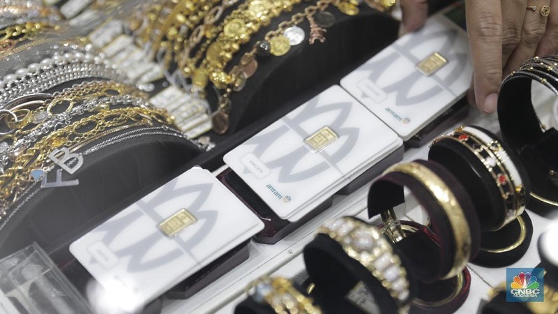 Pengunjung mencoba sejumlah emas yang di jual di toko emas dikawasan Jakarta, Jumat (2/12/2022). Harga emas Logam Mulia produksi PT Aneka Tambang Tbk pada Kamis (1/12/2022) di butik emas LM Graha Dipta Pulo Gadung melonjak Rp10.000 per gram menjadi Rp991.000 per gram. (CNBC Indonesia/Tri Susilo)