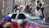 Demonstran di Meksiko merusak mobil pemadam kebakaran saat berunjuk rasa di Hari Perempuan Sedunia. Mereka memprotes tingginya tingkat kekerasan dan pembunuhan terhadap wanita di negara itu. (AP Photo/Rebecca Blackwell)