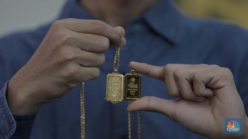 Pengunjung mencoba sejumlah emas yang di jual di toko emas dikawasan Jakarta, Jumat (2/12/2022). Harga emas Logam Mulia produksi PT Aneka Tambang Tbk pada Kamis (1/12/2022) di butik emas LM Graha Dipta Pulo Gadung melonjak Rp10.000 per gram menjadi Rp991.000 per gram. (CNBC Indonesia/Tri Susilo)