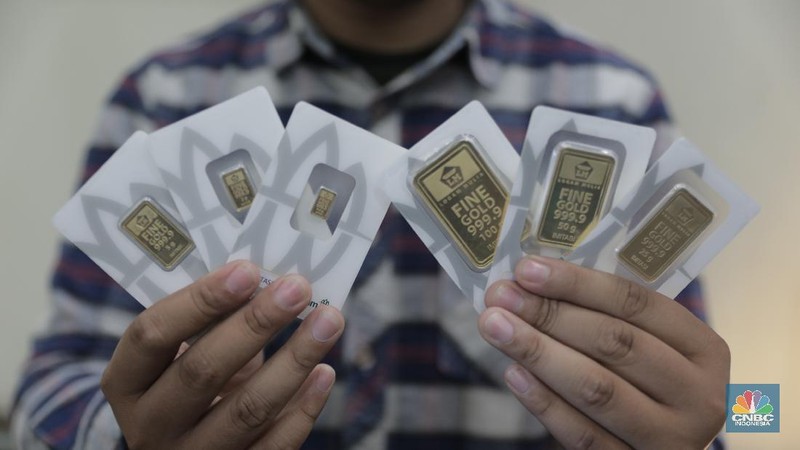 Pengunjung mencoba sejumlah emas yang di jual di toko emas dikawasan Jakarta, Jumat (2/12/2022). Harga emas Logam Mulia produksi PT Aneka Tambang Tbk pada Kamis (1/12/2022) di butik emas LM Graha Dipta Pulo Gadung melonjak Rp10.000 per gram menjadi Rp991.000 per gram. (CNBC Indonesia/Tri Susilo)