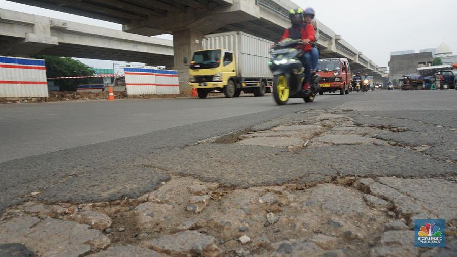 Mengendara melintas di Kawasan Kalimalang, Jakarta, Kamis (12/3). Memasuki musim hujan yang turun hampir setiap hari membuat sejumlah ruas jalan rusak dan tergenang yang mengakibatkan jalan berlubang. Kondisi ini membuat pengendara memperlambat laju kendaraannya untuk berhati-hati saat melintas di titik jalan berlubang. Akibatnya tak jarang terjadi kemacetan panjang di wilayah ini. Pengguna Jalan Kalimalang mengeluhkan kondisi jalan rusak karena dikhawatirkan dapat menimbulkan kecelakaan lalu lintas. Imron salah satu warga yang kesehariannya sering melintas di kawasan Kalimalang mengatakan "Biasanya kalau pagi jam-jam kerja di kawasan Kalimalang macet, karena konstruksi jalan yang jelek". Jalan berlubang di daerah tersebut juga karena faktor proyek Becakayu. Banyak mobil mobil besar melintas sehingga membuat jalan rusak. Selain itu ada juga bekas galian kabel yang terlihat diabaikan sehingga membuat beton penutup lubang hancur. (CNVC Indonesia/Muhammad Sabki)