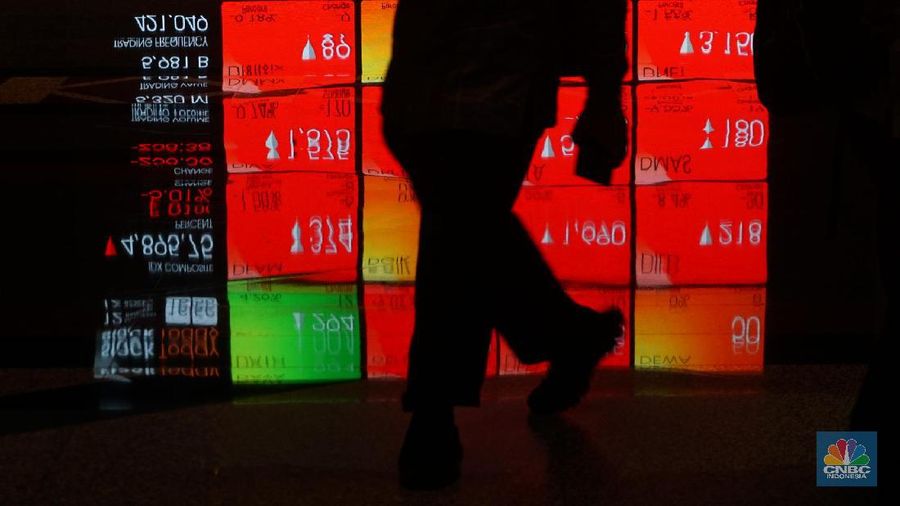 Pengunjung melintas di depan layar pergerakan saham di Bursa Efek Indonesia, Kamis, 12 Maret 2020. Indeks Harga Saham Gabungan (IHSG) anjlok 5,01% ke 4.895,75. Perdagangan saham di Bursa Efek Indonesia (BEI) dihentikan sementara (trading halt) setelah  Harga tersebut ke 4.895,75 terjadi pada pukul 15.33 WIB.  (CNBC Indonesia/Muhammad Sabki)