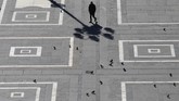 Seorang pria berjalan di alun-alun Duomo di Milan, Italia. Negara di Eropa bagian selatan itu menjadi salah satu negara yang terkena wabah corona, sehingga pergerakan manusia di tempat-tempat wisata harus dibatasi. (AP Photo/Antonio Calanni)