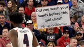 Sebuah poster sindiran yang terkait dengan kebiasaan cuci tangan di tengah isu corona mewarnai pertandingan bola basket antarkampus (NCAA). (Matt Freed/Pittsburgh Post-Gazette via AP)