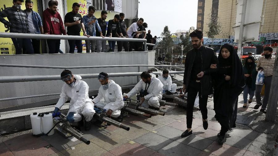 Petugas kebakaran di Iran berjibaku membersihkan jalan-jalan di Iran untuk mencegah bertambahnya korban akibat Covid-19.