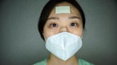 Para perawat di Korea Selatan terlihat memakai perban di dahi, pipi, dan hidung saat mereka bertugas merawat para pasien virus corona (Covid-19). (Photo by Ed JONES / AFP)