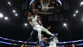 Marcus Smart dari Boston Celtic berupaya melewati adangan pemain Utah Jazz, Rudy Gobert, dalam lanjutan laga NBA. Gobert belakangan diketahui menjadi salah satu atlet yang terinfeksi virus corona. (AP Photo/Winslow Townson)