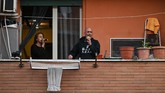 Dalam video lain, komplek apartemen di Kota Turin menyanyikan lagu Spanyol, Macarena untuk mengunggah semangat warga. (Andreas SOLARO / AFP)