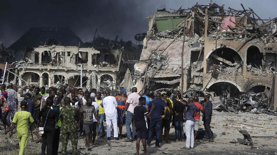 People gather near the site of an explosion in Lagos, Nigeria. Sunday March 15, 2020. An explosion hit Nigeria's commercial capital of Lagos early Sunday, killing at least 15 people and sparking search-and- rescue efforts to save people still trapped in collapsed buildings, emergency officials said. (AP Photos/Sunday Alamba)