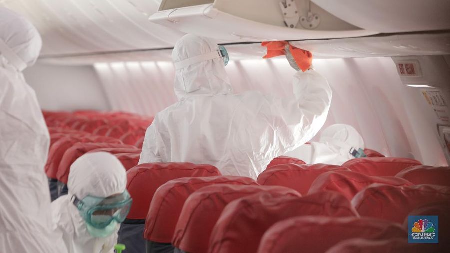 Petugas Kesehatan Bandara Soekarno Hatta, Tangerang Banten melakukan penyemprotan disinfektan ke semua pesawat yang selesai dan yang akan beroprasi. (17/3/2020). (CNBC Indonesia/Tri Susilo)
