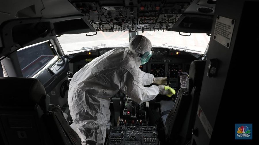 Petugas Kesehatan Bandara Soekarno Hatta, Tangerang Banten melakukan penyemprotan disinfektan ke semua pesawat yang selesai dan yang akan beroprasi. (17/3/2020). (CNBC Indonesia/Tri Susilo)