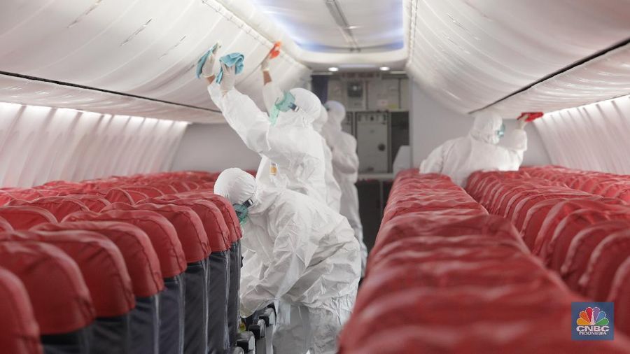 Petugas Kesehatan Bandara Soekarno Hatta, Tangerang Banten melakukan penyemprotan disinfektan ke semua pesawat yang selesai dan yang akan beroprasi. (17/3/2020). (CNBC Indonesia/Tri Susilo)