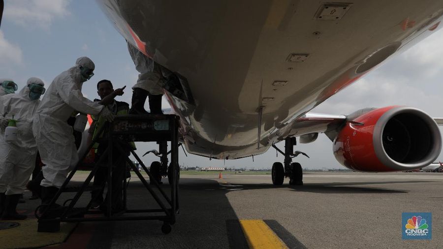 Petugas Kesehatan Bandara Soekarno Hatta, Tangerang Banten melakukan penyemprotan disinfektan ke semua pesawat yang selesai dan yang akan beroprasi. (17/3/2020). (CNBC Indonesia/Tri Susilo)